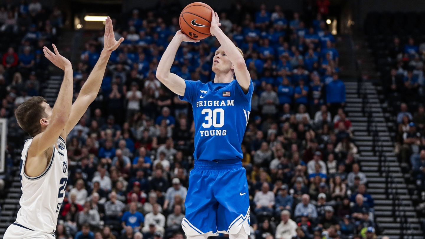 TJ Haws shoots a 3-pointer while a Utah State player challenges the shot at Vivint Smart Home Arena.