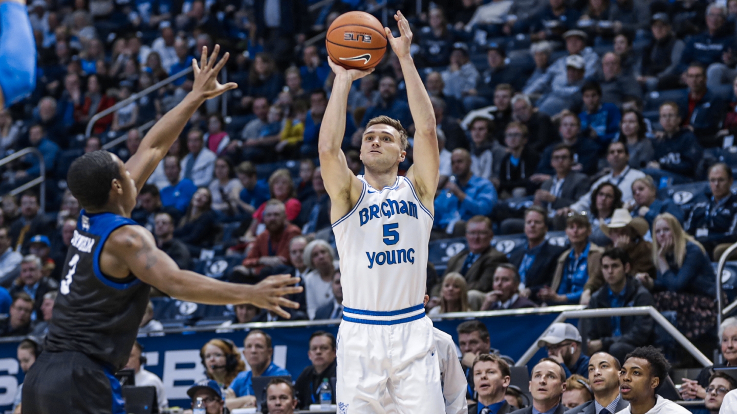 Jake Toolson shoots a 3-pointer while a Weber State player contests his shot.